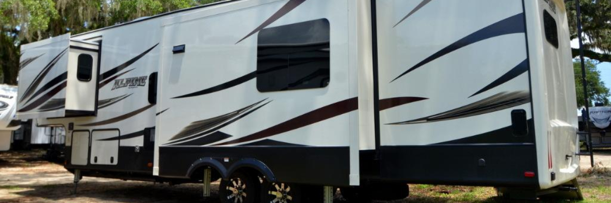 Keystone Alpine RV parked in a lot at a dealership